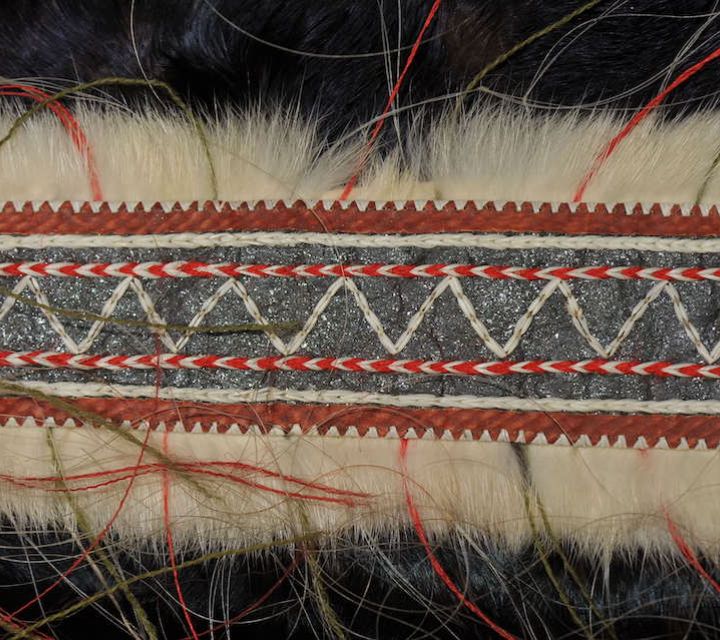 close up view of band of embroidery on a bird skin parka